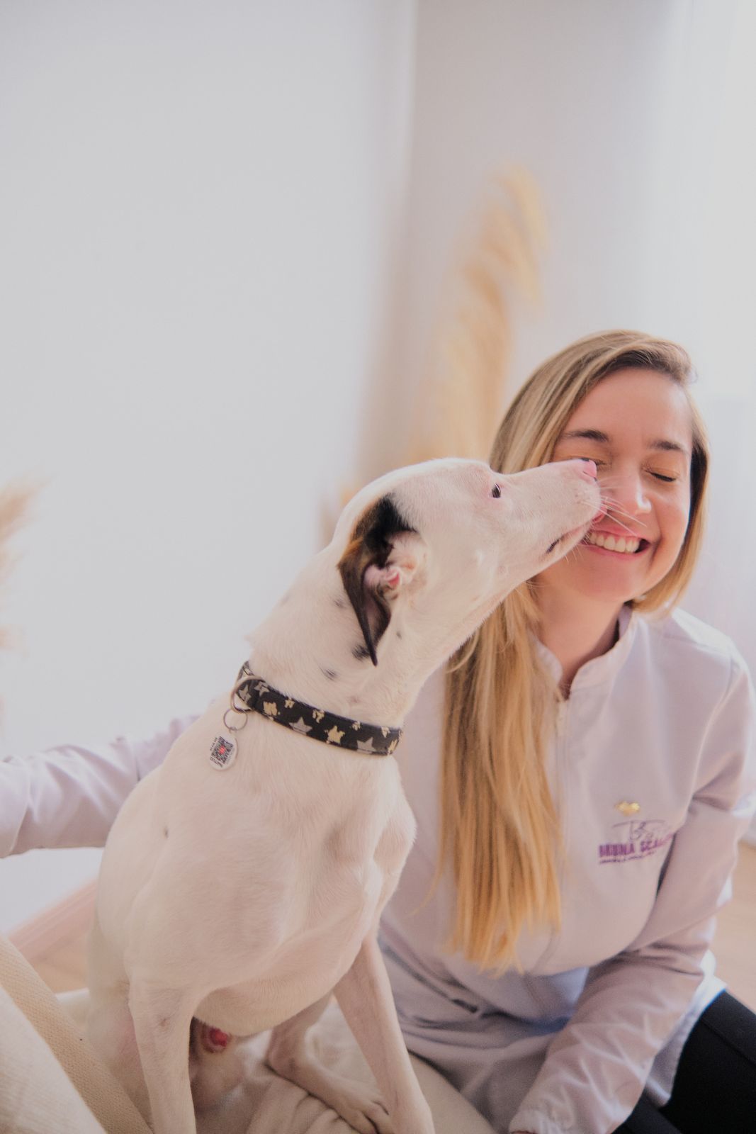 Dra. Bruna sendo lambida por um cachorro paciente